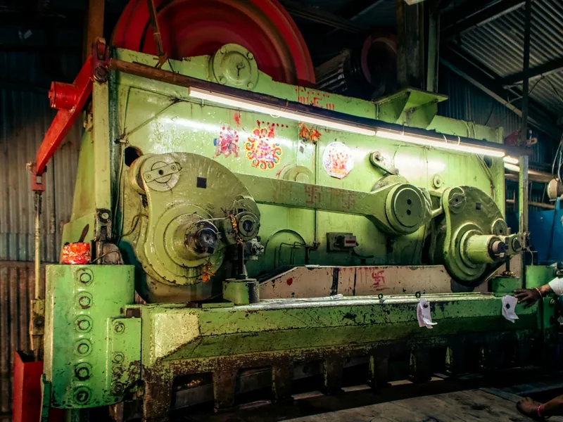 A large industrial metal shearing machine in a workshop.